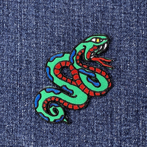 Colorful snake patch on denim fabric
