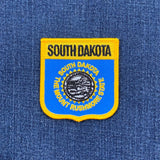 South Dakota state patch on a blue denim background