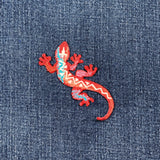 southwest lizard embroidered patch on a denim background