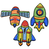 A set of three colorful space-themed applique patches, including a rocket ship, fighter jet, and satellite, designed to be iron on.
