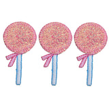 An embroidered appliqué patch depicting three identical pink glitter lollipops. Each lollipop has a bright pink bow tied around a blue and white striped stick.