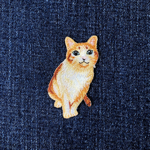 Embroidered cat patch on a denim background
