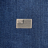 Tan and black American flag patch on a blue denim background