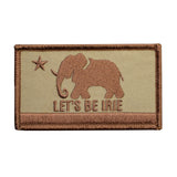 An embroidered rectangular patch featuring a tan elephant and star on a beige background with the text 'LET'S BE IRIE' and a brown border.