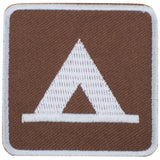 A square embroidered patch with rounded corners, featuring a brown background and a white tent icon in the center, bordered by a white stitched edge.