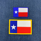 Two Texas flag patches on a denim background