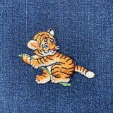 Embroidered tiger design on denim fabric