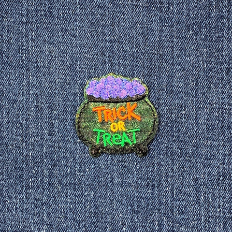 Embroidered patch with 'Trick or Treat' text on a denim background