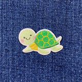 Embroidered turtle patch on denim fabric