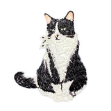 Embroidered patch of a black and white cat on a white background