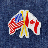 A patch featuring the crossed flags of the United States of America and Canada on a denim background