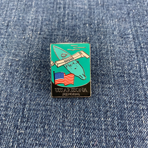 Pin with uss arizona memorial design and American flag on a denim background