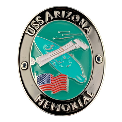 An oval medallion reading 'USS ARIZONA MEMORIAL' with a turquoise center, silver-toned border, a white airplane, and a small American flag at the bottom, shown on a plain white background.