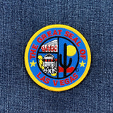 A round embroidered patch with the text 'THE GREAT SEAL OF LAS VEGAS' featuring a casino slot machine, dice, and a cactus on a denim background
