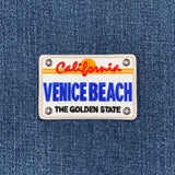 Patch with 'California Venice Beach The Golden State' text on a denim background