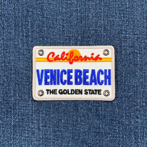 Patch with 'California Venice Beach The Golden State' text on a denim background