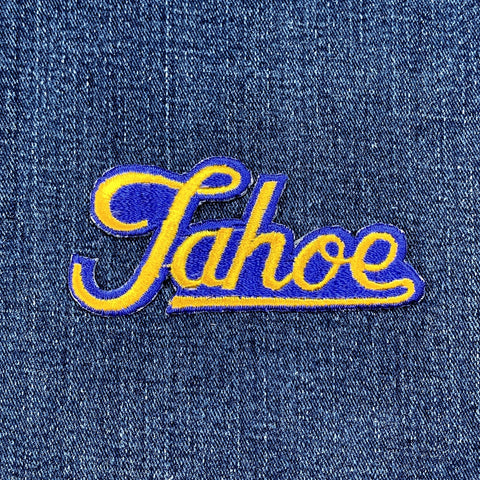 Embroidered patch with 'Tahoe' text on denim fabric