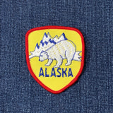 Alaska-themed patch with bear and mountains on a denim background
