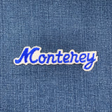 Embroidered patch with 'Monterey' text on denim fabric