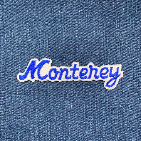 Embroidered patch with 'Monterey' text on denim fabric