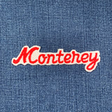 Embroidered patch with 'Monterey' text on denim fabric