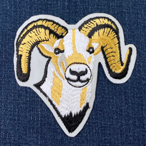 Embroidered patch of a ram's head on denim fabric