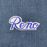 Embroidered patch with 'Reno' text on denim fabric