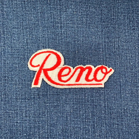 Embroidered patch with 'Reno' text on denim fabric