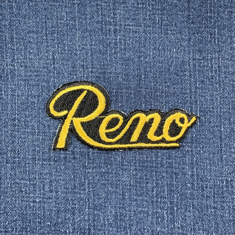 Embroidered patch with 'Reno' text on denim fabric