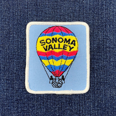 Embroidered patch of a hot air balloon with 'Sonoma Valley' text on a blue denim background.