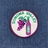 Embroidered patch with 'Sonoma Valley' text, grapes, and a bottle on a denim background