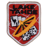 A vintage patch with a red background featuring the text 'LAKE TAHOE' and an illustration of a roulette wheel, playing cards, and dice.