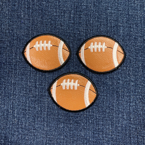 Three football-shaped patches on a denim background