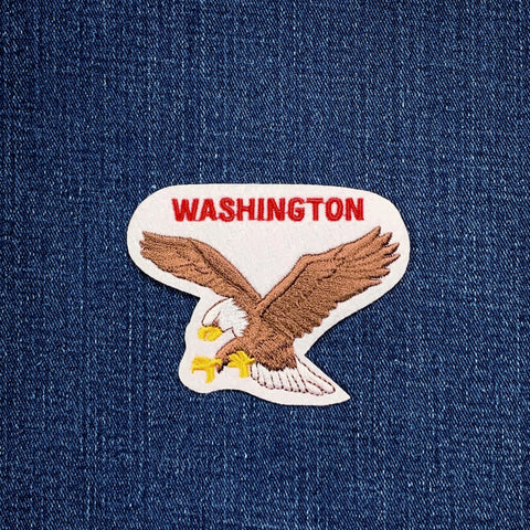 an embroidered patch depicting an eagle with the word 'Washington' across the top on a denim background