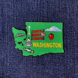 Embroidered patch of Washington state with icons and text on a denim background