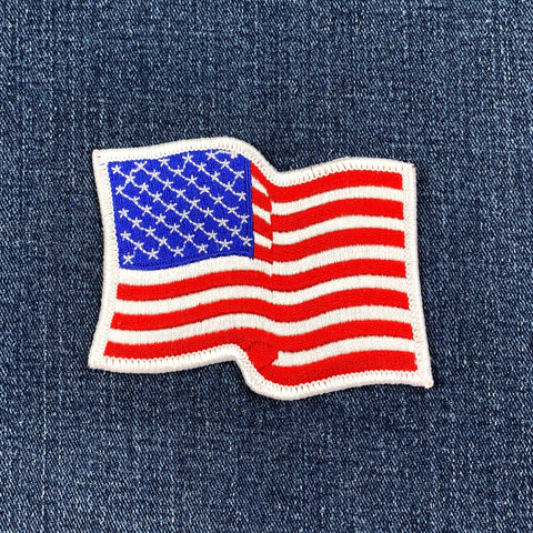 wavy united states flag patch with a white border on a denim background