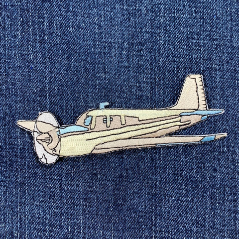 Embroidered airplane patch on denim fabric