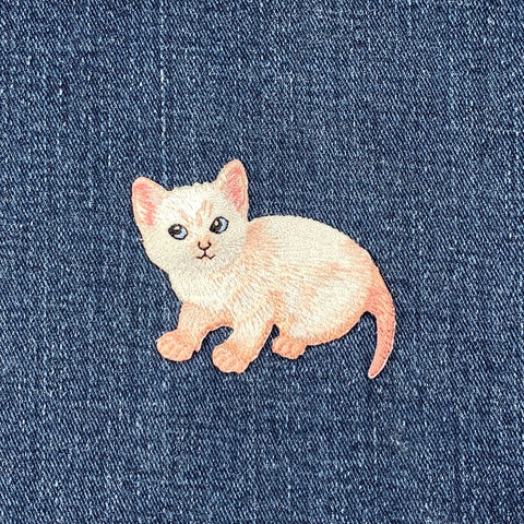 Embroidered cat patch on denim fabric