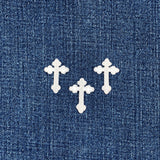 3 White cross-shaped patches on a blue denim background