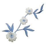 Embroidered floral patch with blue leaves and white flowers on a white background