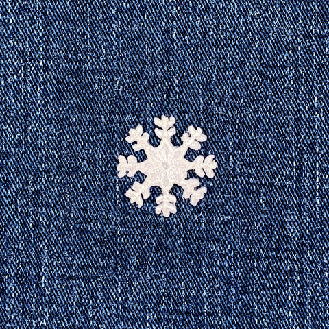White snowflake patch on a blue denim background