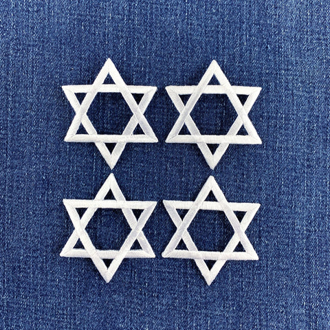Four white embroidered Star of David patches arranged in a 2x2 grid on a textured blue denim fabric background.