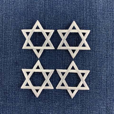 4 white star of David patches on a denim background