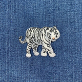 Embroidered black and white tiger patch on a denim background