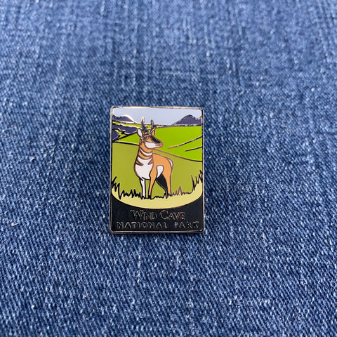 Pin with a pronghorn antelope and Wind Cave National Park design on a denim background