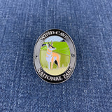 An oval enamel Walking Stick Medallion featuring a pronghorn antelope in a grassy landscape with the text 'WIND CAVE NATIONAL PARK' on a blue denim background.