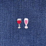 Two embroidered wine glass patches on a denim background