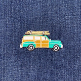 Vintage-style car patch with surfboards on a denim background