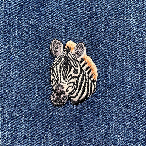 Embroidered zebra patch on denim fabric