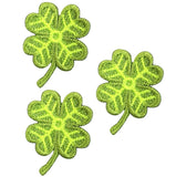 Three embroidered green four leaf clover patches designed to be ironed onto fabric.